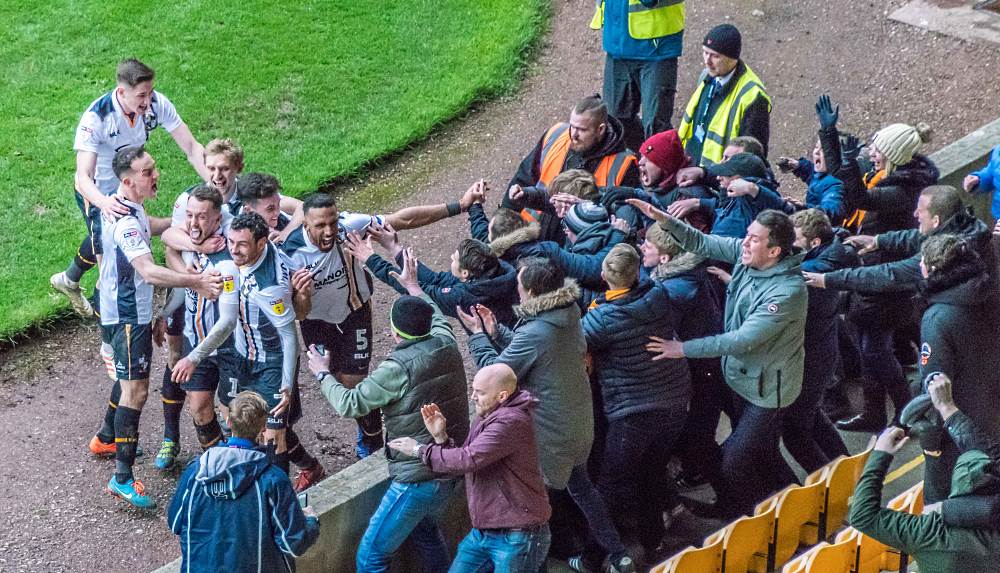 Ricky Miller and teammates celebrate in front of fans during the Mansfield Town game.