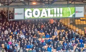 Oldham fans are nonplussed as a Vale goal is signaled on the scoreboard.